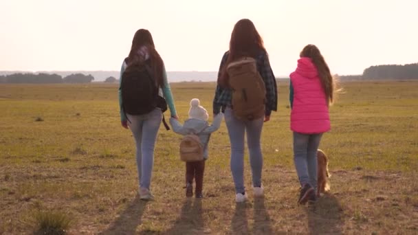 Familia con mochilas viaja con un perro. Trabajo en equipo de una familia muy unida. madre, hijas y hogar mascotas turistas. concepto de unas vacaciones deportivas en familia en la naturaleza . — Vídeos de Stock