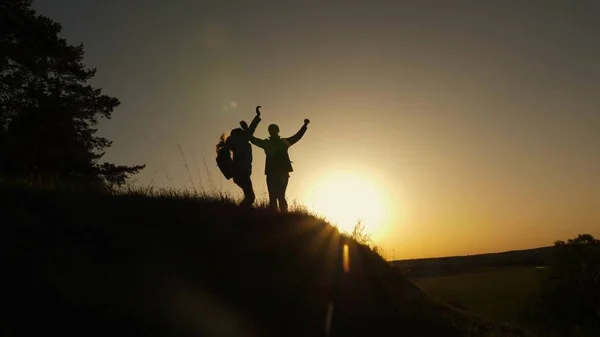 Πεζοπόρος κορίτσι Υψώστε το χέρι της επάνω, γιορτάζοντας τη νίκη και απολαμβάνοντας το τοπίο. μαμά και κόρη σε διακοπές ταξιδεύοντας και χορεύοντας στο βουνό. Γυναίκα με ψηλά χέρια στην κορυφή του βουνού κοιτάζοντας το ηλιοβασίλεμα. — Φωτογραφία Αρχείου
