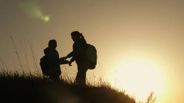 Mamá y su hija de vacaciones viajando y bailando en la montaña. Mujer con las manos levantadas en la cima de la montaña mirando el atardecer. Hiker Girl levantando la mano, celebrando la victoria y disfrutando del paisaje . —  Fotos de Stock