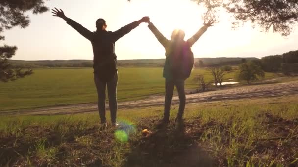 Flicka resenär med en tonårs flicka resa i solnedgången. Höj dina händer. Gratis äventyr. Lagarbete. Seger. Mamma och dotter. Vandra med ryggsäckar. — Stockvideo