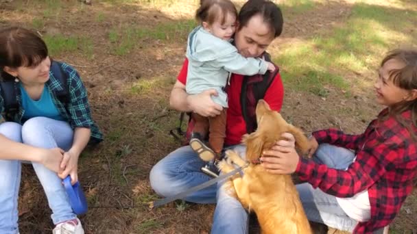 Papá criador con niños y perro para dar un paseo. Una familia feliz. Día de los Papins. Padre e hijas. Cuidado y crianza de perros. Mascotas. Trabajo en equipo. Pat el perro . — Vídeos de Stock