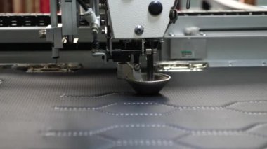 Robot dikiş makinesi. otomatik dikiş makinesi. Robotik terzilik üretim hattında çalışır. Bilgisayar dikiş makinesini kontrol eder. suni deri üzerinde iğne nakış deseni.