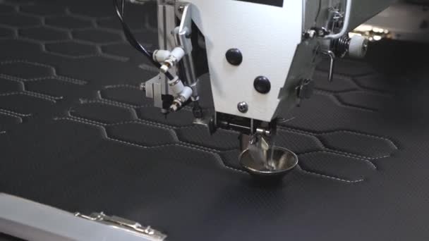 Geautomatiseerd machine Borduur patroon op kunstleer. Robotica werkt in de tailoring productielijn. Robot naaimachine. computer bestuurt de naaimachine. Automatische naaimachine. — Stockvideo