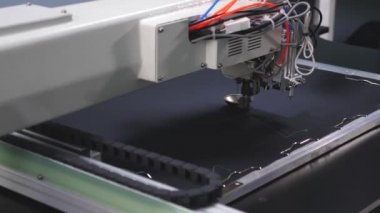 otomatik dikiş makinesi. Robot dikiş makinesi. suni deri üzerinde otomatik makine nakış deseni. Robotik terzilik üretim hattında çalışır. bilgisayar dikiş makinesini kontrol eder.