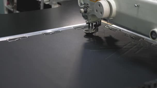 机器人缝纫机。电脑控制缝纫机。自动缝纫机。人造皮革上的自动机器刺绣图案。机器人在裁缝生产线上工作. — 图库视频影像
