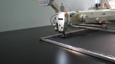 suni deri üzerinde otomatik makine nakış deseni. Robotik terzilik üretim hattında çalışır. Robot dikiş makinesi. bilgisayar dikiş makinesini kontrol eder. otomatik dikiş makinesi.