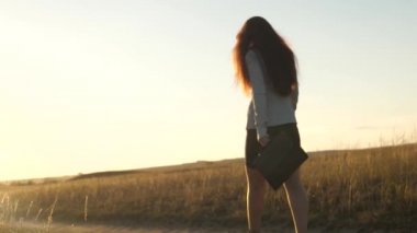 Evrak çantası olan kız işadamı topuklu ayakkabılarla yola çıkıyor. Özgür ve bağımsız bir kadın. İş elbisesi giymiş işadamı.