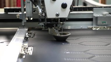 Robot dikiş makinesi. otomatik dikiş makinesi. Robotik terzilik üretim hattında çalışır. Bilgisayar dikiş makinesini kontrol eder. suni deri üzerinde iğne nakış deseni.