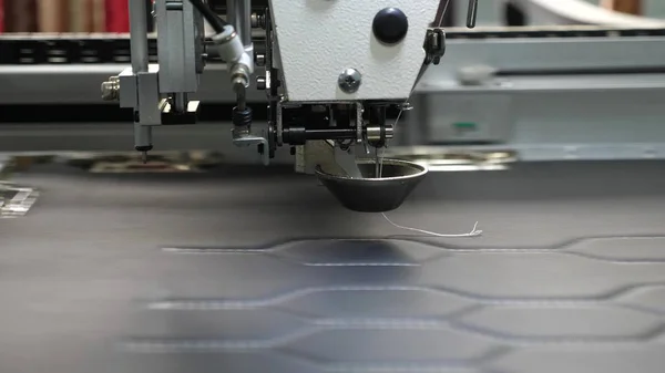 Robot máquina de coser. máquina de coser automática. La robótica trabaja en la línea de producción de sastrería. El ordenador controla la máquina de coser. patrón de bordado de aguja en cuero artificial . — Foto de Stock