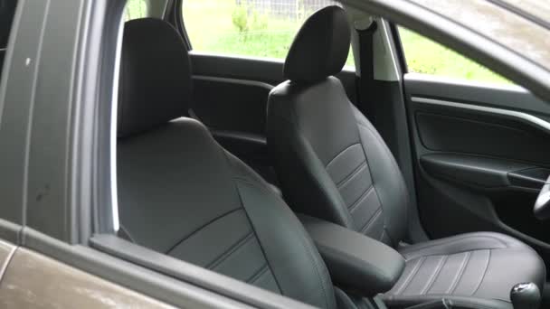 Faux leather front seats in the carr. luxury leather seats in the car. Black leather seat covers in the car. beautiful leather car interior design. — Stock Video