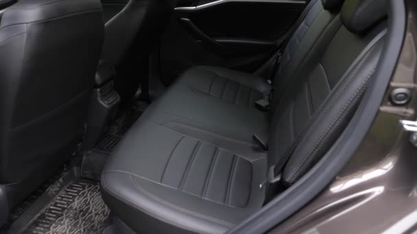 Black leather seat covers in the car. artificial leather rear seats in the car. beautiful leather car interior design. luxury leather seats in the car. Slow motion — Stock Video