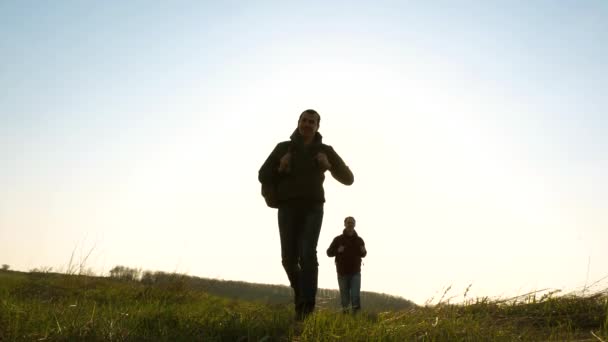 Vrolijke reizigers lopen één voor één de zon in. Business team is in een haast om te winnen en te slagen. Slow Motion. Gelukkige toeristen met rugzakken rennen en zwaaien hun handen. teamwork van zakenmensen. — Stockvideo