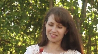 bahçede yaz aylarında çilek yeme mutlu kız. Lezzetli çilek tatlısı. güzel kız bir fincan kırmızı çilek yiyor ve gülümsüyor. Kadınlar için vitamin ve Berry Diyet.