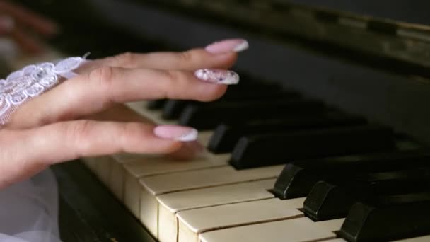 Handen van het meisje in witte handschoenen met een mooie manicure spelen de piano. Speel de melodie op de noten. Muziekbedrijf. Close-up — Stockvideo