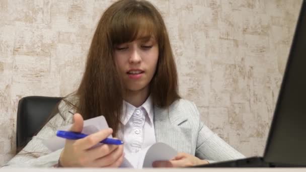 Vacker flicka sitter i en stol på kontoret och prata och att göra anteckningar i bloknot. ung kvinnlig entreprenör som arbetar med en klient i ett kontor — Stockvideo