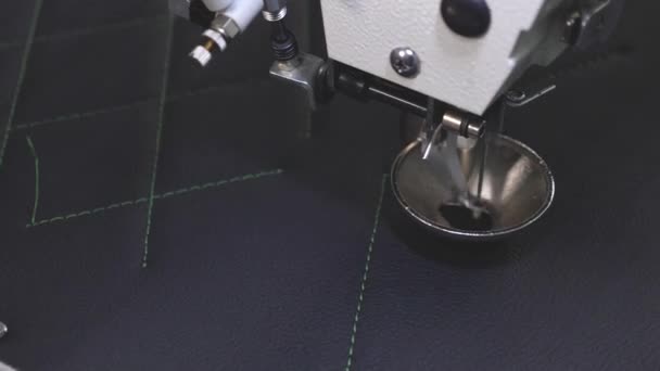 Roboternähmaschine. Der Computer steuert die Nähmaschine. Nähautomaten. automatisierte maschinelle Stickmuster auf Kunstleder. Robotik arbeitet in der Schneiderei-Fertigungslinie. — Stockvideo