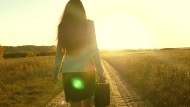 seksi iş kadını kız kırsal alanda çalışarak. kadın çiftçi kara gün batımında olup olmadığını denetler. tarım iş kavramı. iş kadını onun elinde bir çanta ile köy yolunda yürüyorduk.