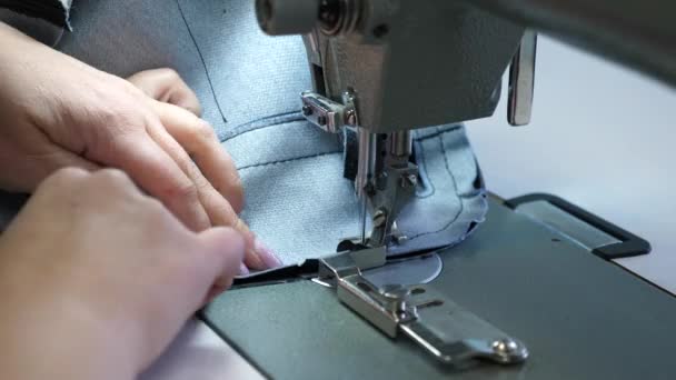 Proceso de coser artículos de cuero. La aguja de la máquina de coser en movimiento. dos agujas de la máquina de coser se mueve rápidamente hacia arriba y hacia abajo, de cerca. Sastre cose cuero negro en un taller de costura . — Vídeos de Stock