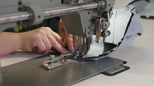 Proceso de coser artículos de cuero. La aguja de la máquina de coser en movimiento. dos agujas de la máquina de coser se mueve rápidamente hacia arriba y hacia abajo, de cerca. Sastre cose cuero negro en un taller de costura . — Vídeos de Stock