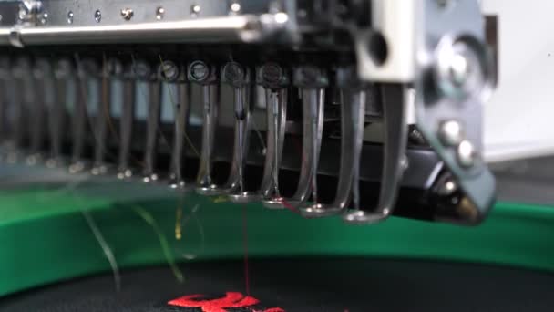 Robot sewing machine. automatic sewing machine. an automated machine embroiders pattern with red threads on a black cloth. Robotics works in tailoring production line. — Stock Video