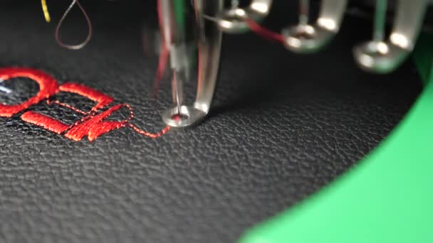 Machine à coudre robotisée. machine à coudre automatique. un motif de brodeur automatique avec des fils rouges sur un tissu noir. Robotique travaille dans la ligne de production sur mesure . — Video