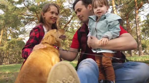 Família feliz com um cão e crianças em uma viagem de acampamento. Adolescentes despreocupados com seu pai em um dia de folga. Caminhadas. Férias. Um criador de cães com um cão e crianças para um passeio . — Vídeo de Stock
