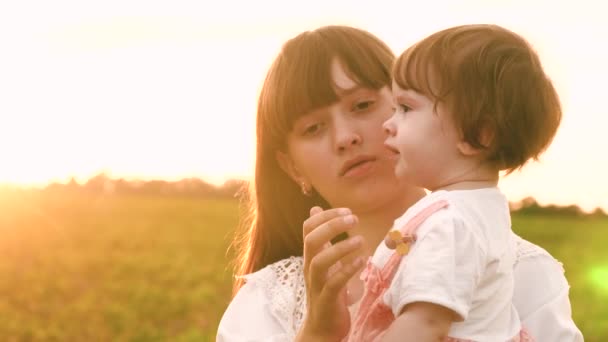 Kind gähnt in den Armen der Mutter, Kind will schlafen, Mutter legt Tochter ins Bett, Familienspaziergang im Sommer im Park. Zeitlupe — Stockvideo