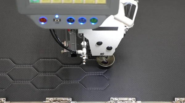 Robotik terzilik üretim hattında çalışır. Robot dikiş makinesi. otomatik dikiş makinesi. Bilgisayar dikiş makinesini kontrol eder. suni deri üzerinde iğne nakış deseni. — Stok fotoğraf