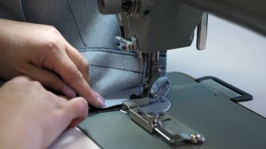 deri eşya dikiş süreci. Dikiş makinesinin iğnesi hareket halinde. dikiş makinesinin iki iğnesi hızlı bir şekilde yukarı ve aşağı, yakın çekim hareket eder. Terzi bir dikiş atölyesinde siyah deri diker.