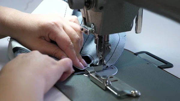 Proceso de coser artículos de cuero. La aguja de la máquina de coser en movimiento. dos agujas de la máquina de coser se mueve rápidamente hacia arriba y hacia abajo, de cerca. Sastre cose cuero negro en un taller de costura . — Foto de Stock