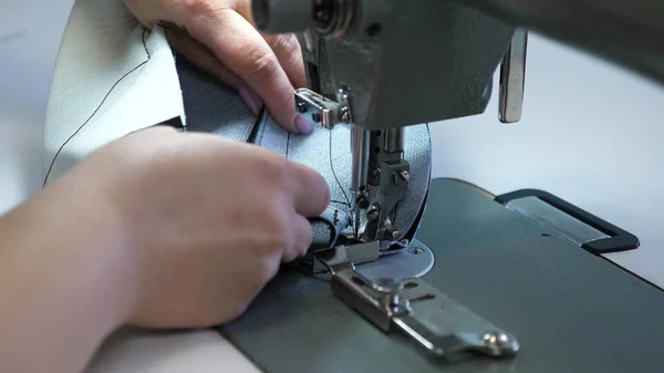 Process av sömnad lädervaror. Nålen på symaskinen i rörelse. två nålar av symaskinen rör sig snabbt upp och ner, närbild. Skräddare syr svart läder i en Syverkstad. — Stockfoto