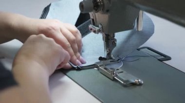 hareket içinde dikiş makinesinin iğne, yakın çekim. dikiş makinesinin iğne hızlı bir şekilde yukarı ve aşağı hareket eder. deri eşya dikiş süreci. Terzi dikiş atölyesinde siyah deri diker.