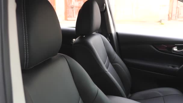 Cubiertas de asiento de cuero negro en el coche. interior del coche de lujo con asientos de cuero negro . — Vídeo de stock