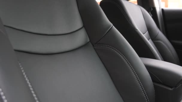 Роскошный интерьер автомобиля с черными кожаными креслами. Черные кожаные чехлы в машине . — стоковое видео