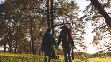 Çam ormanında Hiker Girler. Turist yaşam ve doğa sahiptir. tatil macera seyahat. Mutlu aile seyahatleri. Anne ve kızı yolcuları bir sırt çantası ile ormanda yürüyüş.