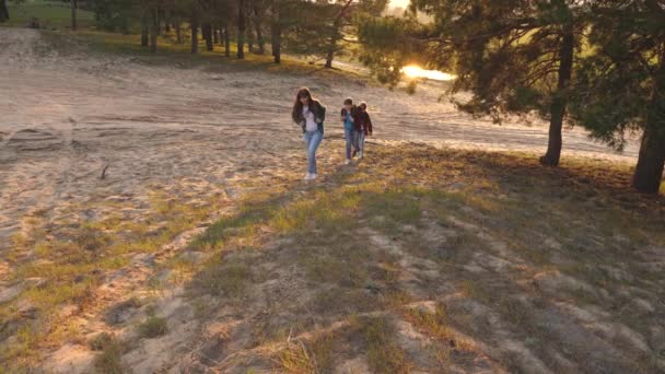 Niñas felices viajan en el bosque, subir la colina, dar una mano. Hiker Girl. familia camina en el bosque. niñas viajan con mochilas en la carretera del campo. Una familia feliz de vacaciones. concepto de turismo deportivo . — Vídeos de Stock