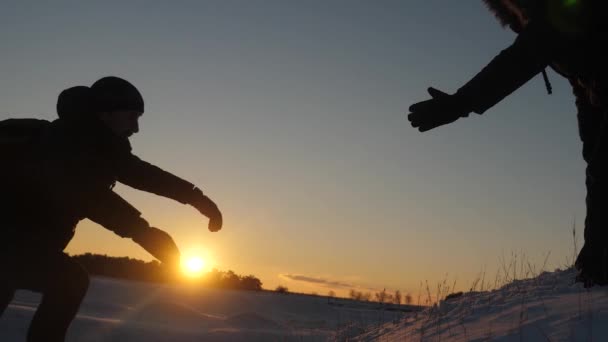Mannen te helpen elkaar te veroveren van de top van hoge besneeuwde berg door hand in hand en stretching elkaar naar boven bij zonsondergang. Natuurlijke koude wanneer ze reizen. Extreme wandelingen voor dapperen — Stockvideo