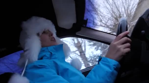 Dívka za volantem automobilu tančí a zpívá. Žena jezdí autem i v zimě sníh. Nezávislé a bez ženy — Stock video