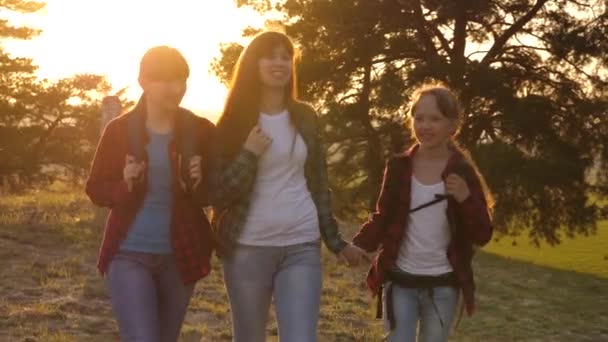 Hiker Girl. familia camina por el bosque. las niñas viajan, pasan por el bosque.las niñas viajan con mochilas en una carretera rural. Una familia feliz de vacaciones. concepto de turismo deportivo . — Vídeos de Stock