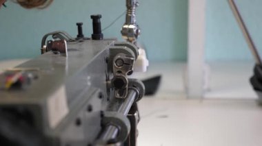 deri eşya dikiş süreci. Dikiş makinesinin iğnesi hareket halinde. dikiş makinesinin iki iğnesi hızlı bir şekilde yukarı ve aşağı, yakın çekim hareket eder. Terzi bir dikiş atölyesinde siyah deri diker.
