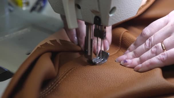 Needle of sewing machine in motion. a seamstress sews black leather in a sewing workshop. needles of sewing machine quickly moves up and down, closeup. rocess of sewing artificial leather. — Stock Video