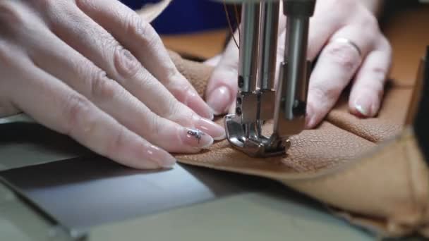 Deux aiguilles de machine à coudre se déplace rapidement de haut en bas, gros plan. tailleur coud cuir marron dans un atelier de couture. processus de couture de cuir artificiel. aiguille de machine à coudre en mouvement . — Video