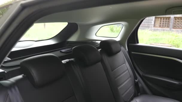 Asientos de cuero de lujo en el coche. En cámara lenta. hermoso diseño interior del coche de cuero. Cubiertas de asiento de cuero negro en el coche. asientos traseros de cuero artificial en el coche . — Vídeo de stock