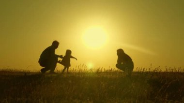 Anne ve baba küçük kızları ile oynarlar. mutlu çocuk babadan anneye geçer. anne ve baba güneşte kızları ile oynamak. 1 yıllık bir çocuk ile genç aile. aile mutluluğu kavramı.