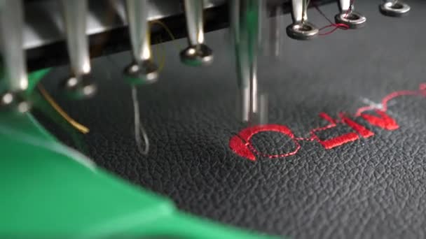 An automated machine embroiders pattern with red threads on black cloth. Robot sewing machine. automatic sewing machine. Robotics works in tailoring production line. — Stock Video