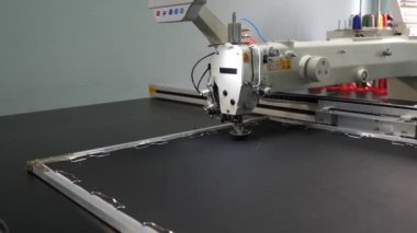 otomatik dikiş makinesi. Robot dikiş makinesi. yapay deri üzerinde otomatik makine nakış deseni. Robotics, üretim hattını uyarlamada çalışmaktadır. bilgisayar dikiş makinesini kontrol eder.