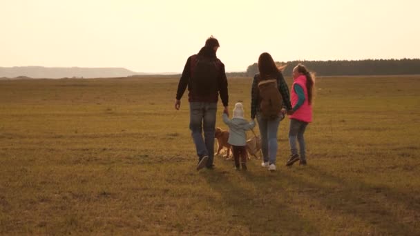 Familia viaja con el perro en la llanura. Trabajo en equipo de una familia muy unida. madre, hijito e hijas y mascotas turistas. El concepto de unas vacaciones en familia deportivas en la naturaleza . — Vídeos de Stock