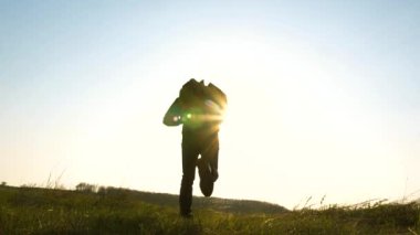 Sırt çantaları ile mutlu gezginler koşmak ve ellerini sallamak. Yavaş çekim. iş adamlarının ortak çalışması. Erkekler uçmanın hayalini kurarlar. neşeli turistler güneşe koşmak.