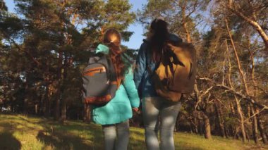 Yürüyüşçü Girs bir çam ormanında. Mutlu aile seyahatleri. anne ve kızı gezginler bir sırt çantası ile ormanda yürüyüş. Turist yaşam ve doğa sahiptir. tatil macera seyahat.