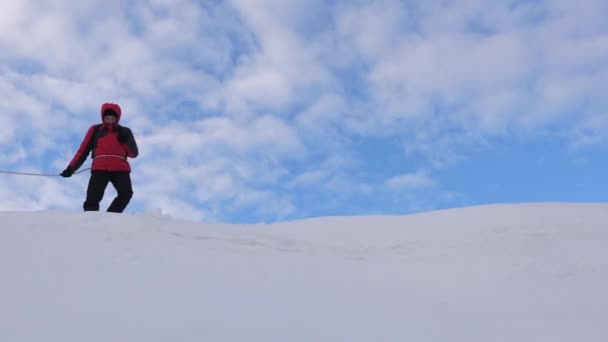 Trabajo en equipo coordinado, turismo en invierno. ir a la victoria. montañista se siguen unos a otros a lo largo de la cresta de nieve, viajeros atados con cuerda. turistas va a la cima de la montaña . — Vídeos de Stock